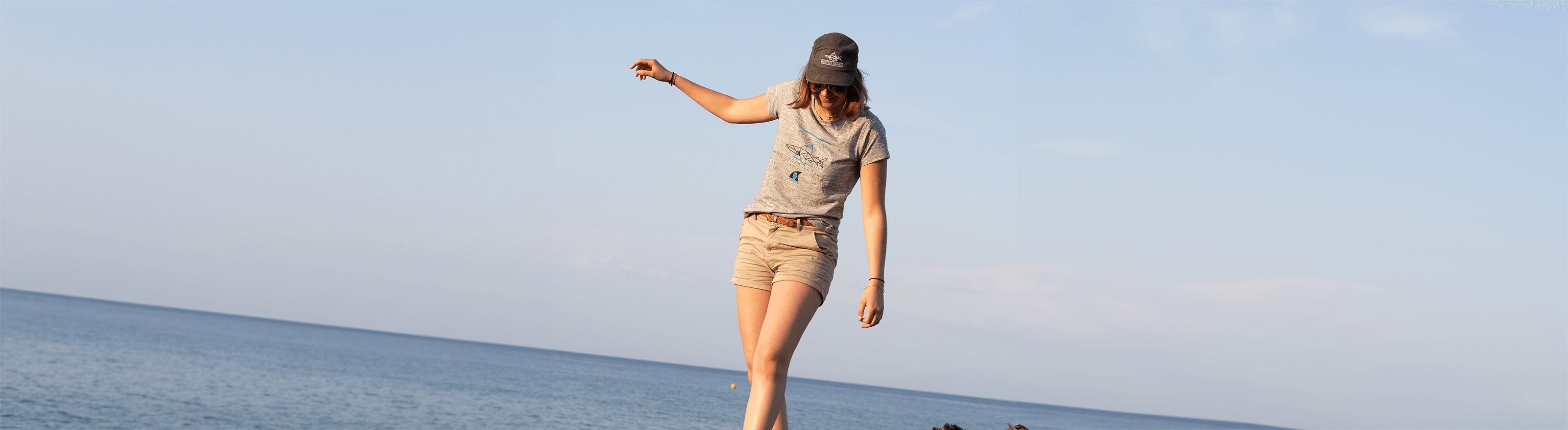 Une femme marche en bord de mer et porte un tshirt Keep Calm Protect Sharks